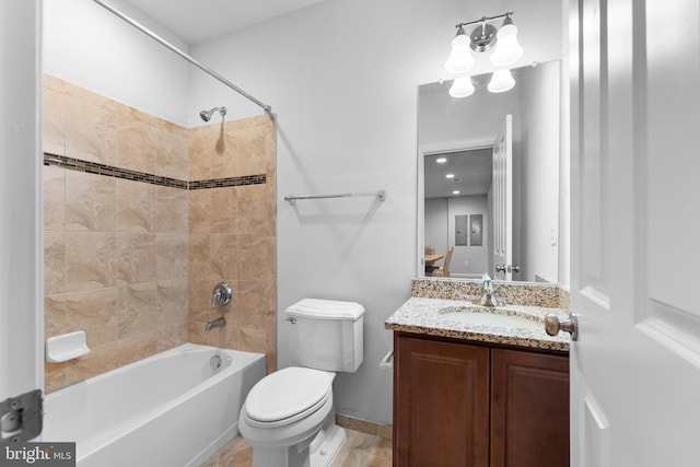 full bathroom featuring tiled shower / bath combo, vanity, and toilet