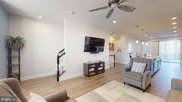 living room featuring sink and light hardwood / wood-style floors