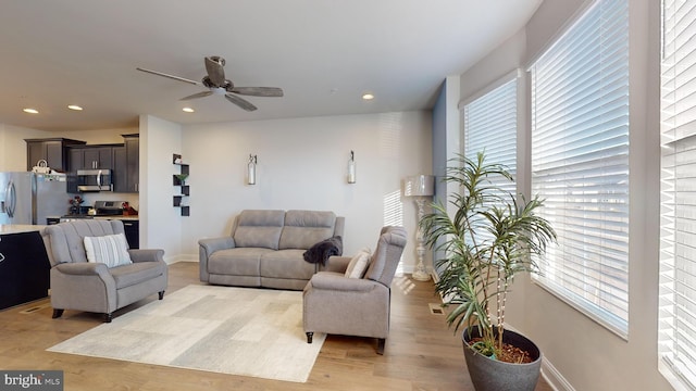 living room featuring light hardwood / wood-style floors and ceiling fan