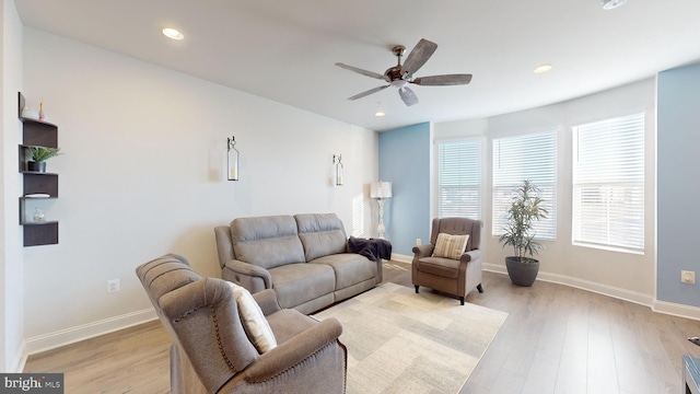 living room featuring light hardwood / wood-style flooring and ceiling fan