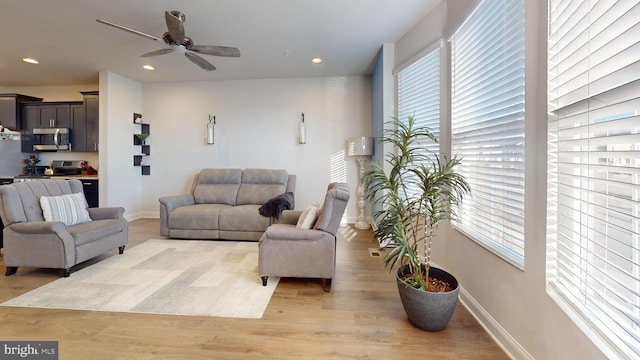 living room with ceiling fan and light hardwood / wood-style floors