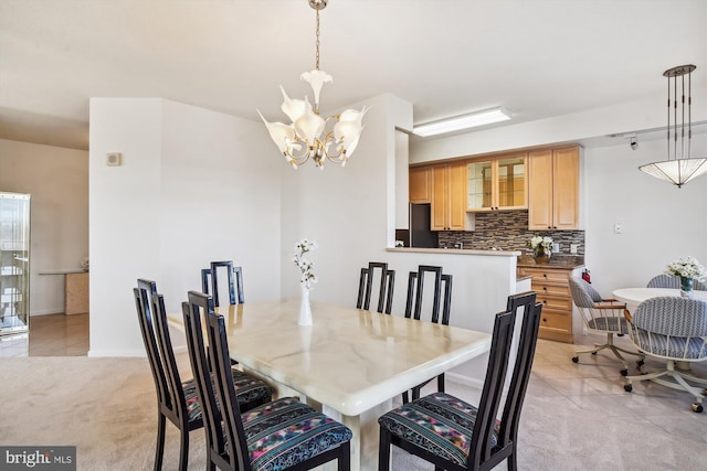 dining area with light tile patterned floors, a notable chandelier, and light colored carpet