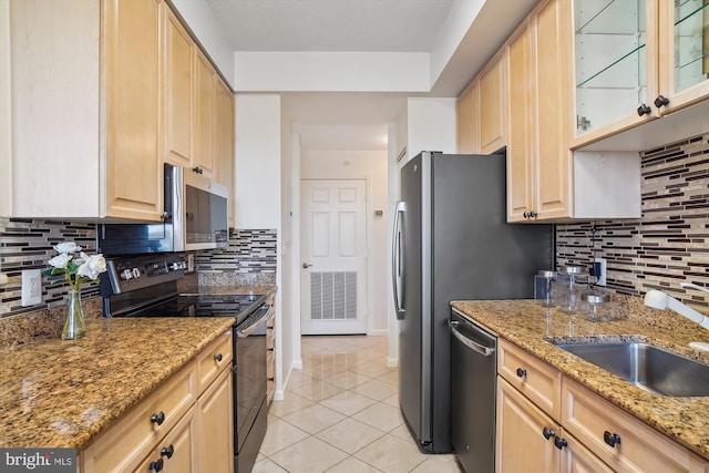 kitchen featuring light tile patterned floors, light brown cabinets, appliances with stainless steel finishes, and a sink