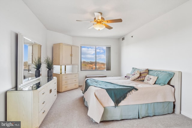 bedroom with light carpet, visible vents, and a ceiling fan