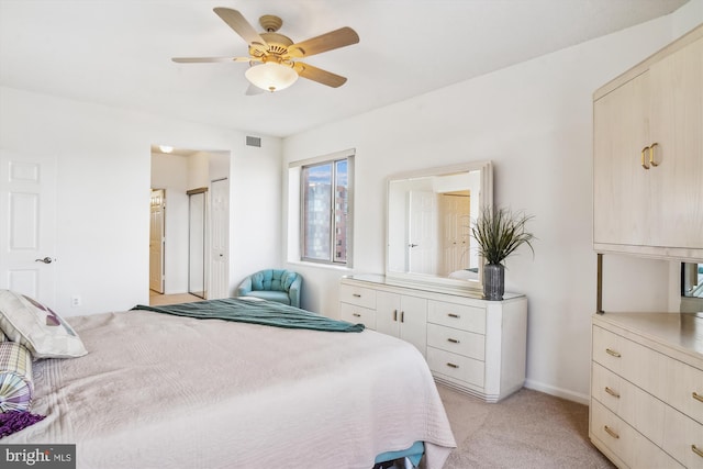 bedroom with visible vents, ensuite bathroom, light carpet, ceiling fan, and baseboards