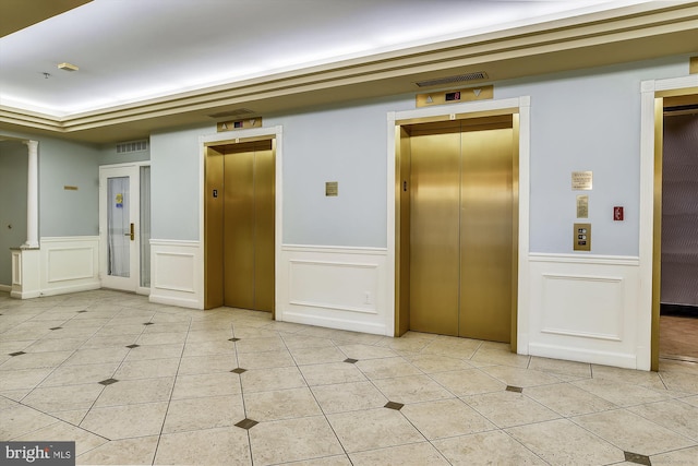 unfurnished room featuring elevator, visible vents, a wainscoted wall, and light tile patterned floors