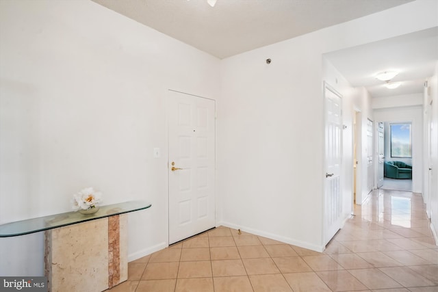 interior space with light tile patterned floors and baseboards