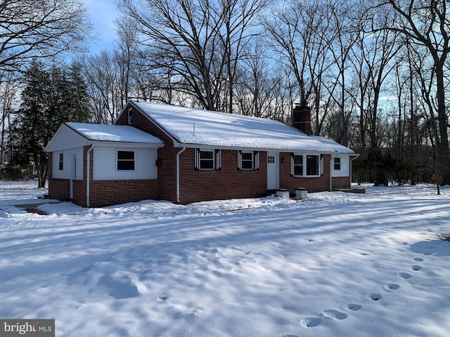 view of front of house with brick siding and a chimney