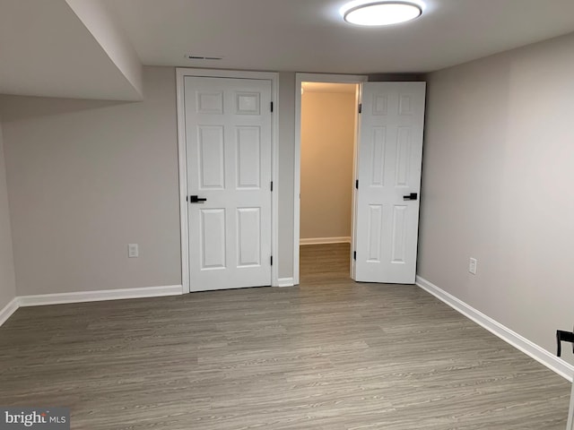 unfurnished bedroom with visible vents, baseboards, and wood finished floors