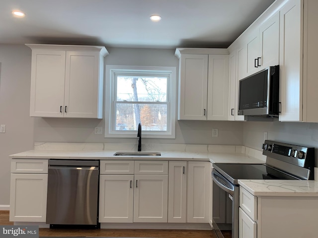 kitchen featuring stainless steel appliances, recessed lighting, white cabinetry, and a sink