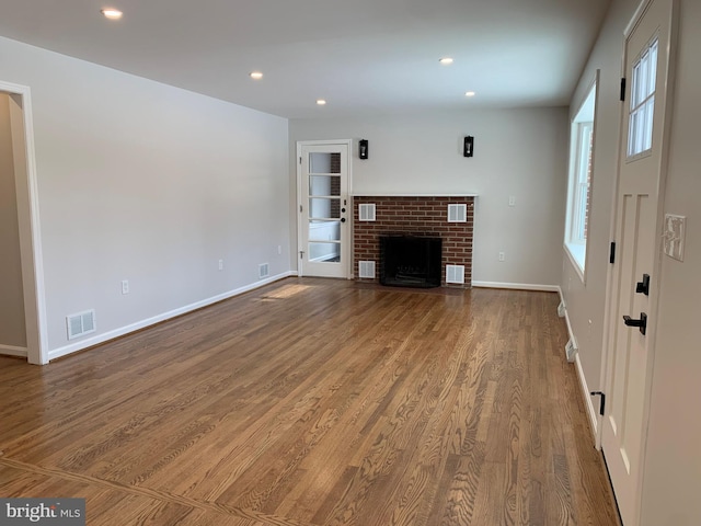 unfurnished living room with wood finished floors, visible vents, and recessed lighting