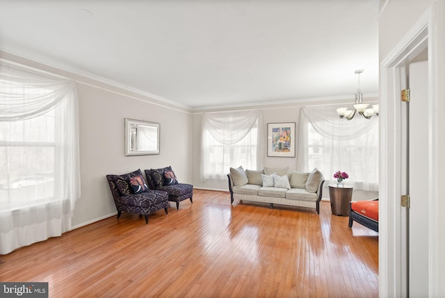 living room featuring hardwood / wood-style flooring, ornamental molding, and a chandelier