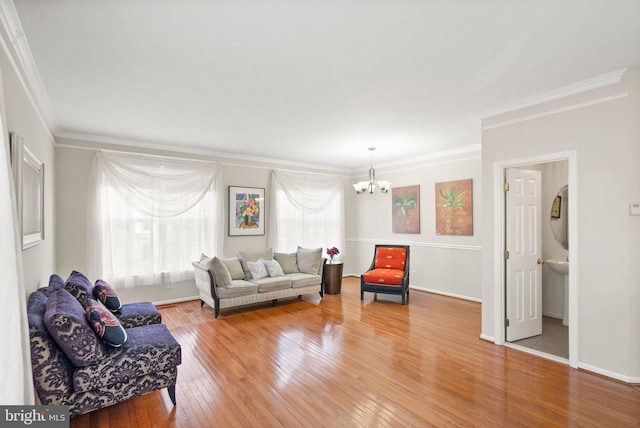 living room featuring hardwood / wood-style flooring, crown molding, and a chandelier