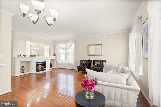 living room featuring hardwood / wood-style flooring, crown molding, and a chandelier