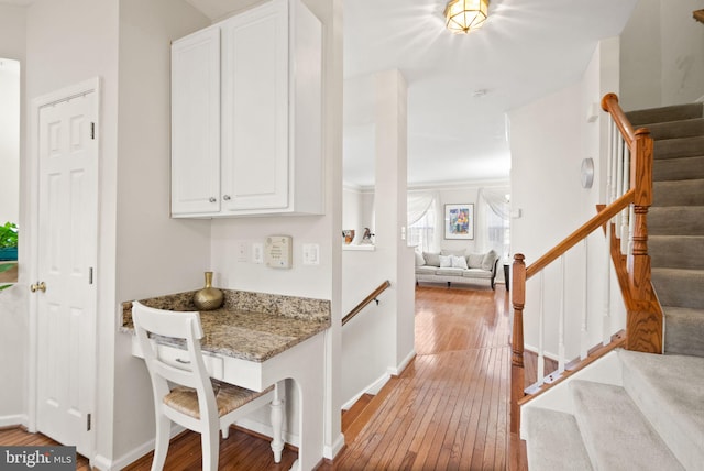 kitchen with white cabinetry, light stone countertops, and light hardwood / wood-style floors