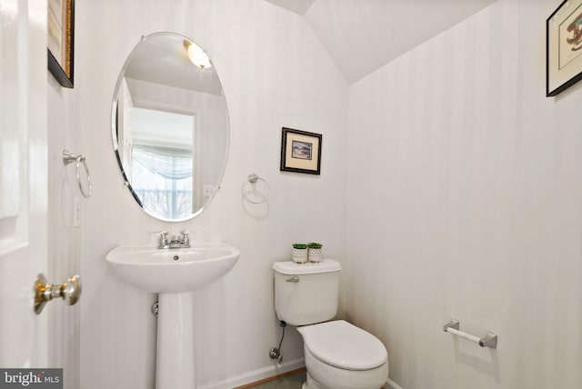 bathroom with lofted ceiling, sink, and toilet