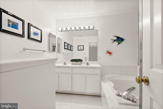 bathroom with vanity and tiled tub