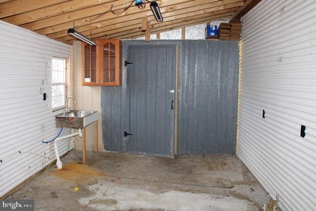 basement featuring wooden walls