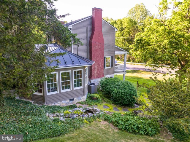 view of side of property featuring a lawn and central air condition unit