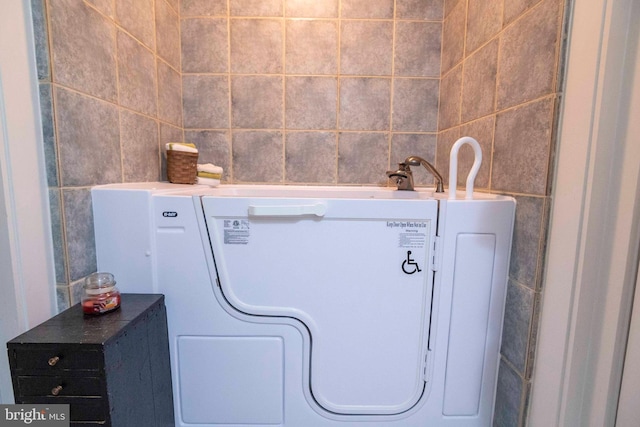 clothes washing area with tile walls