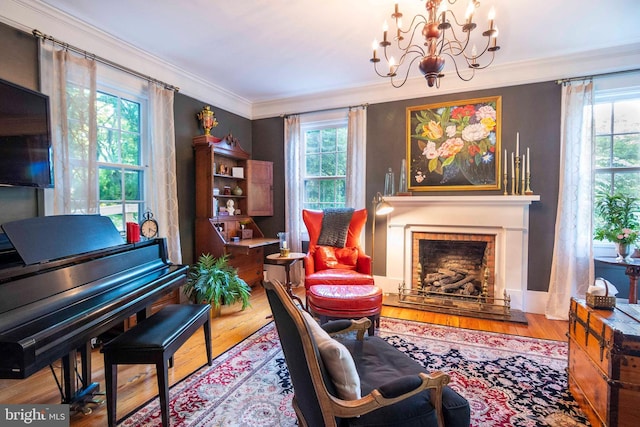 sitting room featuring wood-type flooring, an inviting chandelier, and crown molding