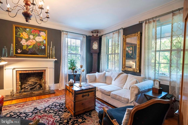 living room with wood-type flooring, a notable chandelier, and ornamental molding