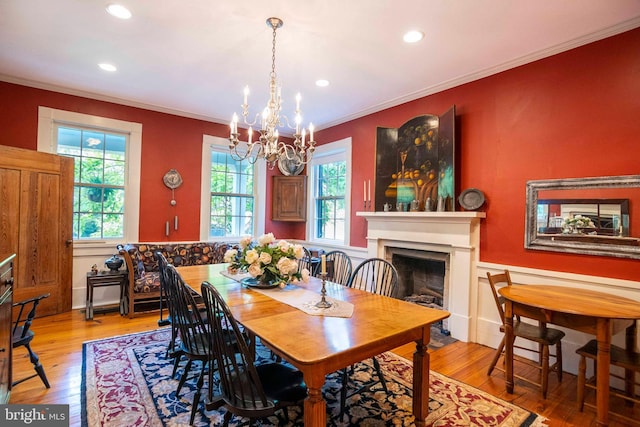 dining area featuring wood-type flooring, crown molding, and a chandelier