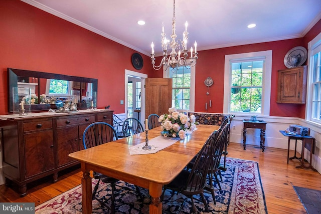 dining area featuring light wood-type flooring, an inviting chandelier, and ornamental molding