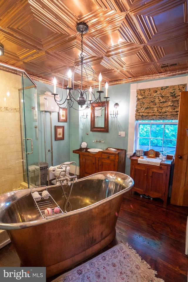 bathroom with hardwood / wood-style floors, vanity, a chandelier, and shower with separate bathtub