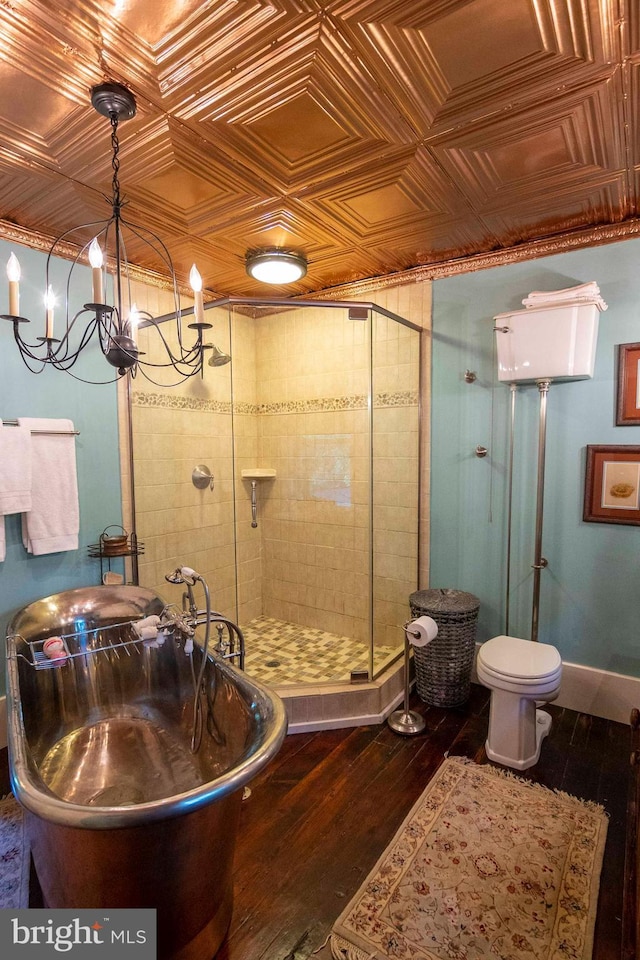 bathroom with hardwood / wood-style flooring, toilet, a notable chandelier, and independent shower and bath