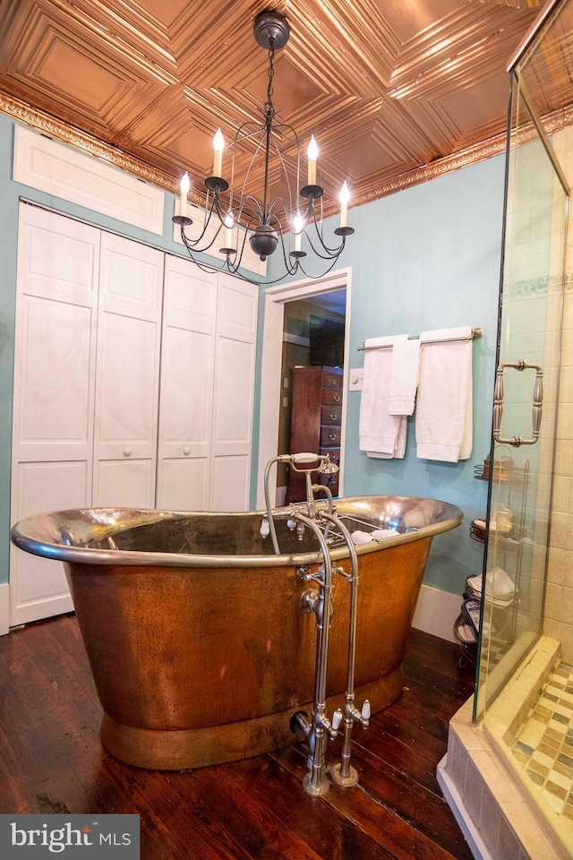 bathroom featuring wood-type flooring, an inviting chandelier, and plus walk in shower