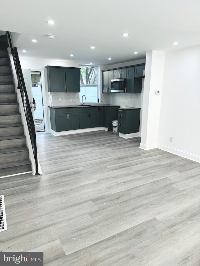 kitchen featuring tasteful backsplash, sink, and light hardwood / wood-style flooring