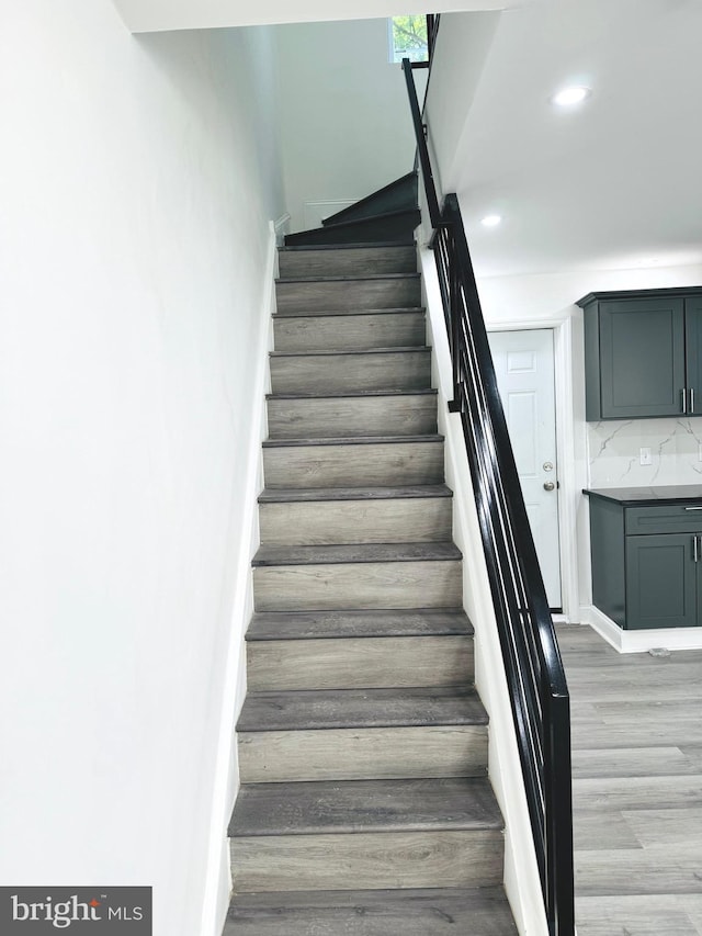 stairs featuring hardwood / wood-style flooring