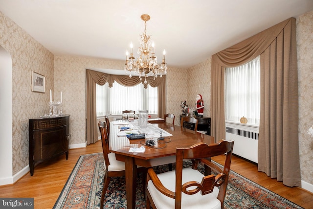 dining room featuring light hardwood / wood-style flooring, radiator, and a chandelier