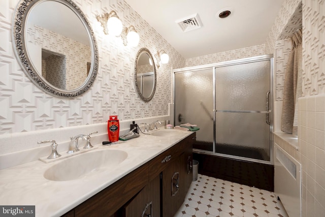 bathroom featuring enclosed tub / shower combo and vanity