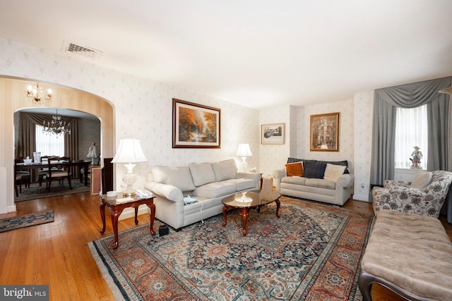 living room with an inviting chandelier and hardwood / wood-style flooring