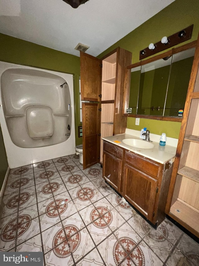 bathroom with toilet, tile patterned flooring, and vanity