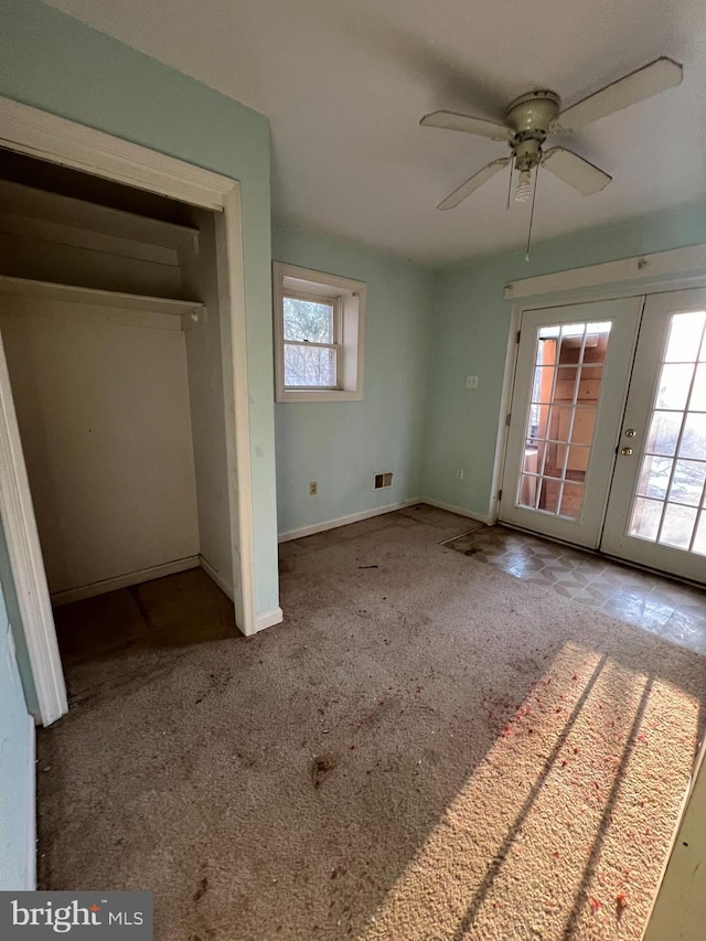 unfurnished bedroom with carpet, french doors, a closet, access to outside, and ceiling fan