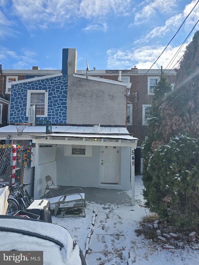 view of snow covered back of property