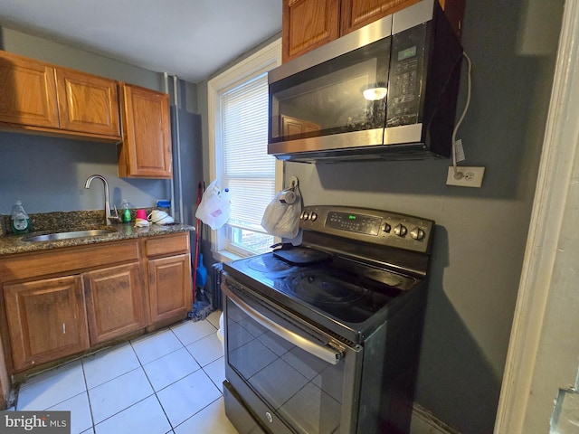 kitchen with light tile patterned floors, appliances with stainless steel finishes, sink, and plenty of natural light