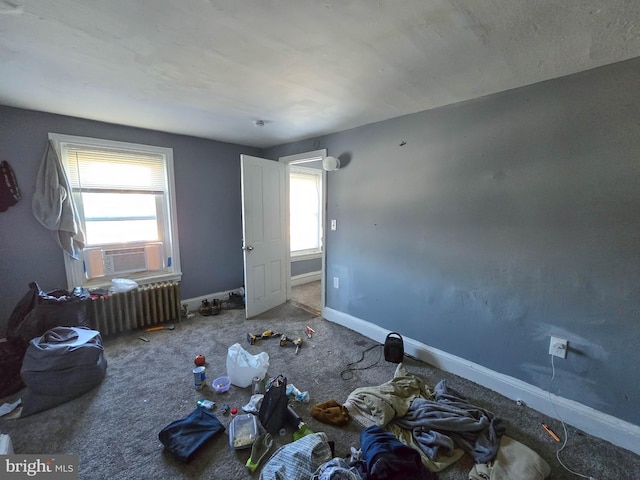 unfurnished bedroom featuring radiator, cooling unit, and carpet floors