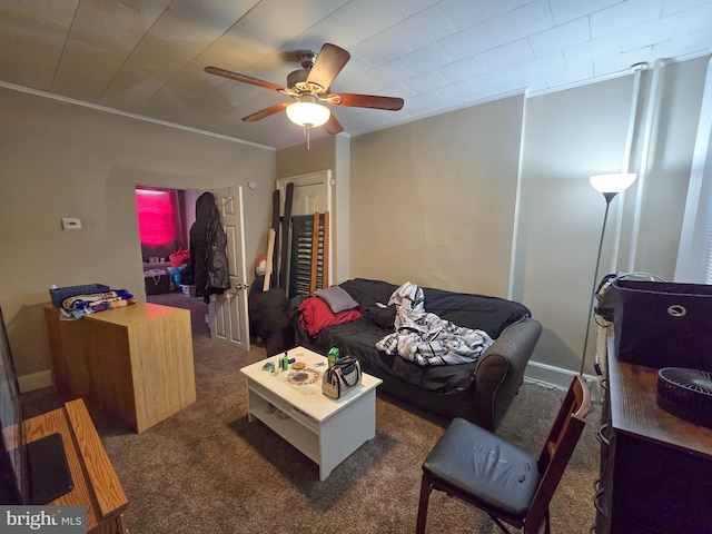 living room with ceiling fan, crown molding, and dark colored carpet