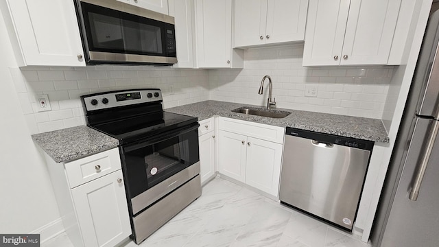 kitchen featuring light stone counters, sink, white cabinetry, and stainless steel appliances