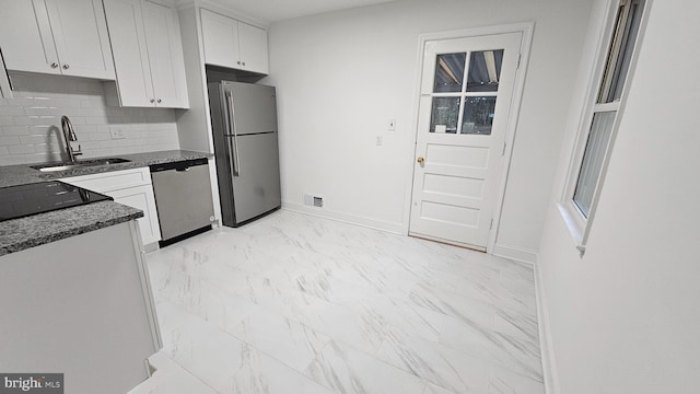 kitchen featuring white cabinets, backsplash, sink, and stainless steel appliances