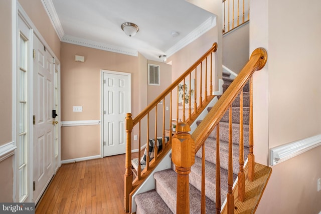 foyer featuring hardwood / wood-style floors and crown molding