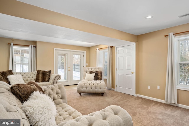 living room featuring light colored carpet, plenty of natural light, and french doors