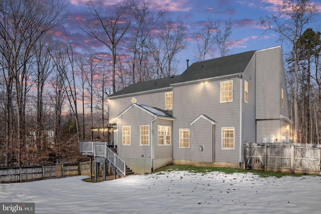 snow covered house with a wooden deck