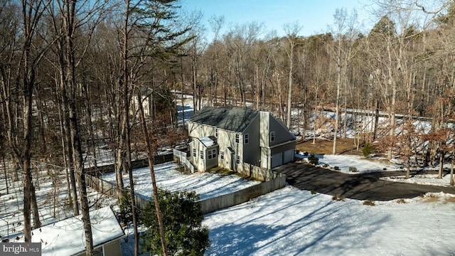 snow covered property with a garage