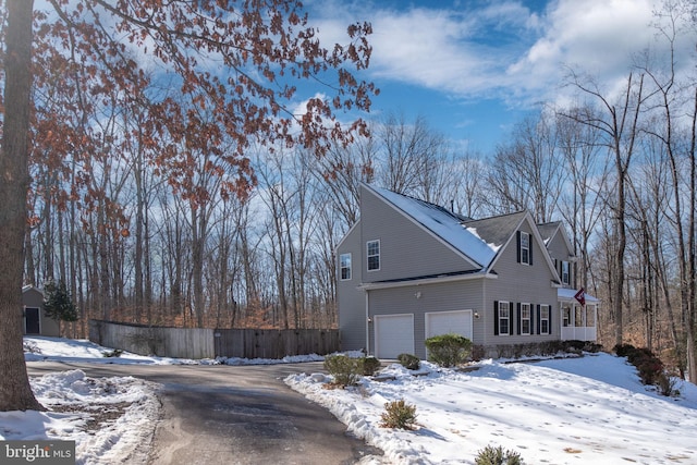 view of snowy exterior with a garage