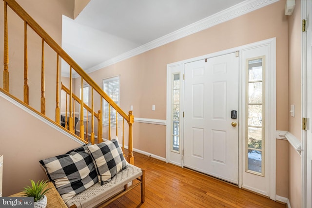 entrance foyer featuring ornamental molding and light wood-type flooring